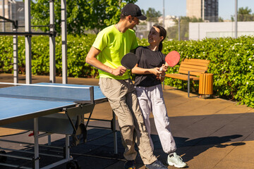 Happy man with his daughter playing ping pong in park