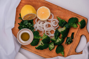 Broccoli, onion, chopped lemons, olive oil on a wooden board. Recipe. Healthy eating