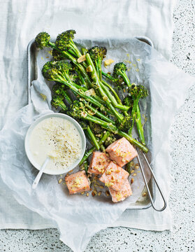 Baked salmon near roasted broccoli with soup in tray