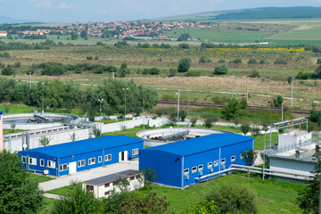 Industrial Facility with Blue Buildings and Tanks in Rural Landscape