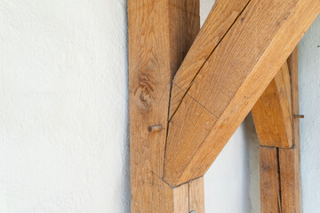 Detailed View of Rustic Wooden Beams Against a White Wall