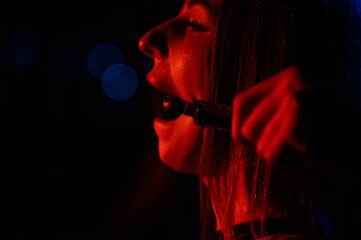 A man gags a woman. BDSM concept.