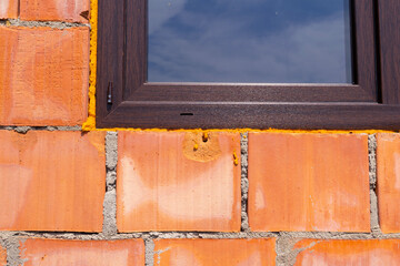 Close-Up of Brick Wall with Window Reflecting Sky