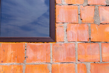Close-Up of Brick Wall with Window Reflecting Sky