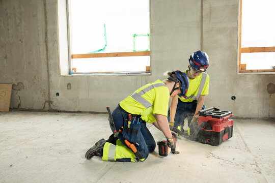Full length of engineers in protective workwear working at construction site