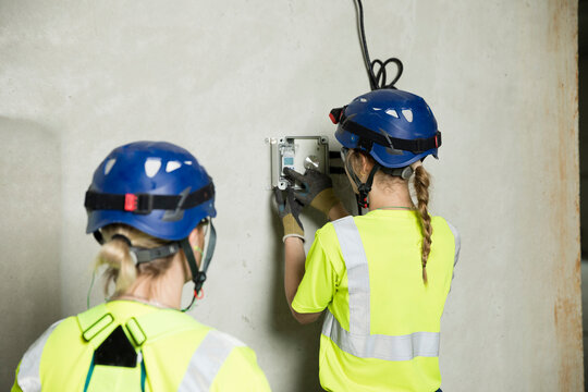Female engineers working on electrical equipment at construction site