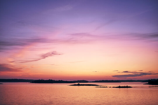 Silhouette islands in sea against sky during sunset