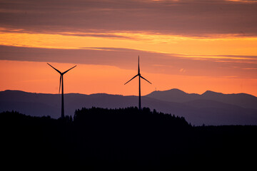 facing a sunset with windmills