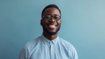 Obraz premium a smiling handsome black businessman wearing a shirt and glasses, feeling confident, isolated on a light blue background.