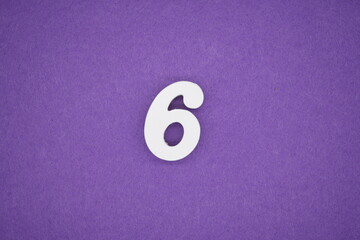 The numbers are made of white paint wood, placed on the background as a purple paper.