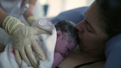 Nurse's hand trying to make newborn baby cry right after birth, infant's first seconds of life...