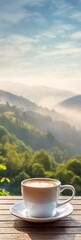 A serene morning view of misty mountains with a steaming cup of coffee on a wooden table, capturing the essence of tranquility and nature.