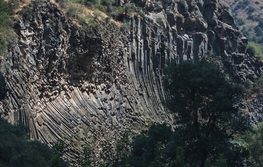 Geological structure known as basalt columnar jointing, with curved and straight columns. Armenia.