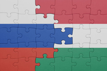 puzzle with the colourful national flag of hungary and flag of russia.