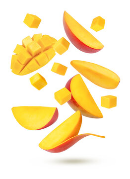 Red ripe mango slices flying in the air isolated on white background.