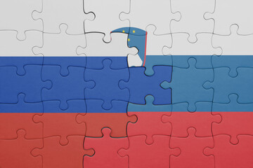 puzzle with the colourful national flag of slovenia and flag of russia.