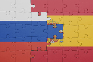 Fototapeta premium puzzle with the colourful national flag of spain and flag of russia.
