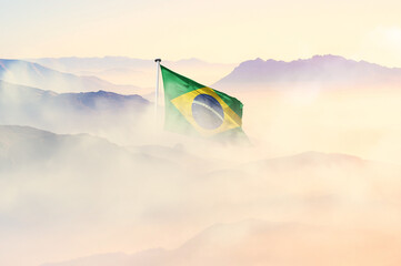 Brazil flag disappears in beautiful clouds with fog.