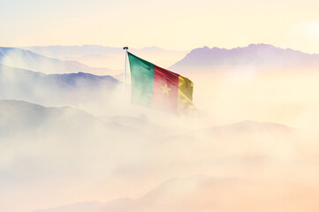 Cameroon flag disappears in beautiful clouds with fog.