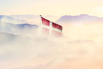 Denmark flag disappears in beautiful clouds with fog.