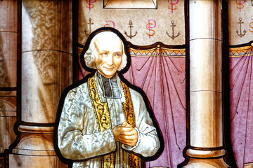 A stained glass of Saint Jean Marie Vianney. Notre-Dame de La Salette, France. Vitrail de Saint...