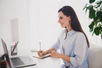 Portrait of pretty lady watch video laptop take notes desktop white interior home office indoors