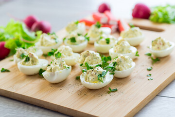 stuffed eggs, deviled eggs on a wooden table