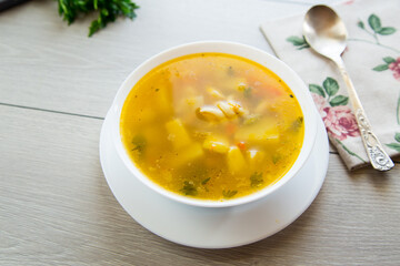 Homemade chicken vegetable soup on rustic wooden background
