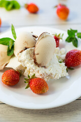 fresh organic cottage cheese with strawberries and ice cream in a plate on a wooden table