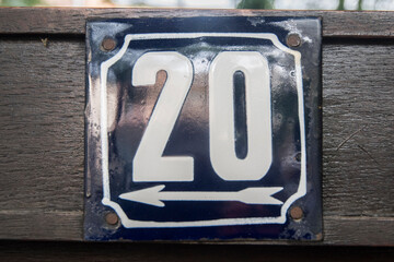 Weathered grunge square metal enameled plate of number of street address with number 20