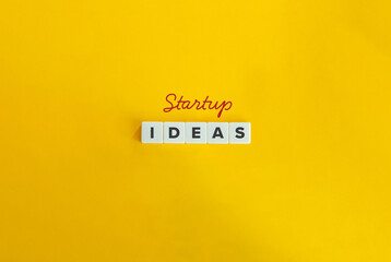 Startup Ideas Banner. Concept of a New Business and Entrepreneurship. Text on Block Letter Tiles on Yellow Background. Minimalist Aesthetics.