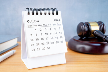 Desk calendar for October 2024 and judge's gavel.