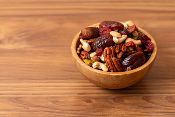 Natural raw foods ingredients and nuts arranged inside a bowl on a wooden table in a flat layout copy space image place for adding text or design. World Pulses Day. African Raw Foods