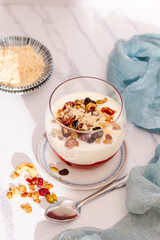 Layered Greek Yogurt Parfait with Jam, dried berries and granola in a Glass. Light and airy real Food photography.