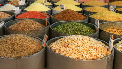 close-up view of various types of beans and legumes in steel buckets in the market in the old town of Taroudant