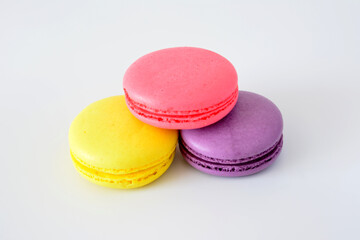 three colorful macaroons with pink, yellow and purple colors