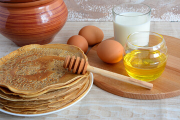 a table with eggs and pancakes and a clay pot 