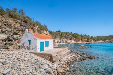 small fisherman's cottage next to a traditional Mediterranean fishermen's quarter, on the shore of a rocky beach. Cala S'alguer, Palamos, Costa Brava, Girona, Catalonia, Spain