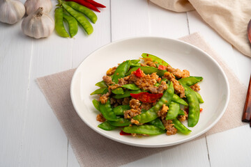 Stir fried snow peas with minced pork in white plate.Thai style food.