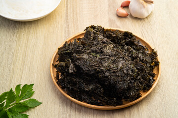 Uncooked dried seaweed in wooden plate,food ingredient for clear soup.