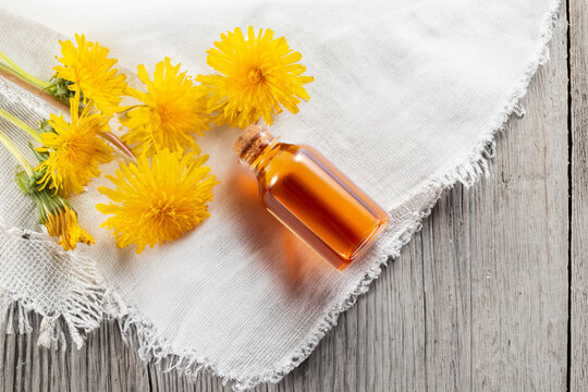 Dandelion flowers and dandelion flowers tincture on cloth. Flat lay