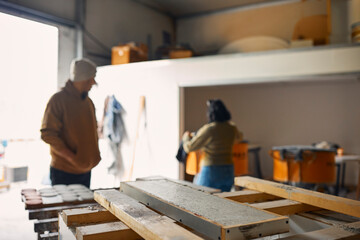 Male And Female Workers In Concrete Workshop 