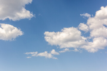 Winter cold air blue sky background with fluffy white clouds
