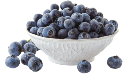 A white bowl overflowing with ripe blueberries sits atop a clean white table