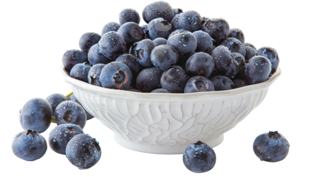 A white bowl overflowing with ripe blueberries sits atop a clean white table