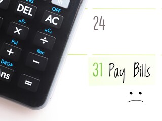 Bill payment day concept: a calendar showing the text "Pay bills" on the 31st and a black calculator