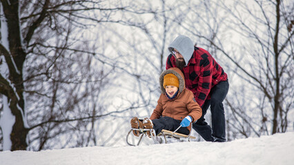 Father and son winter games in a beautiful winter nature background