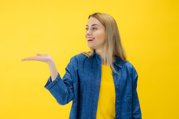 young woman pointing empty place on her palm, copy space advertising area on hand, expressing...