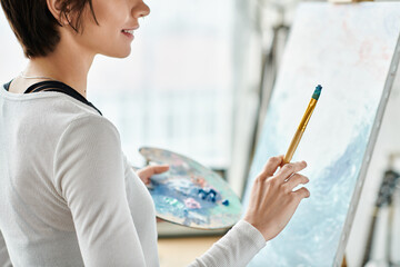 A woman holds a pencil, captivated by a painting.