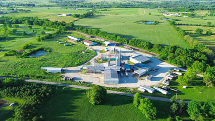 Large feed mill fertilizer agro processing plant with grain silos, griding machines, warehouses, storage tanks, dust collector, agricultural service, regional farm supply, Mountain Grove, aerial © trongnguyen